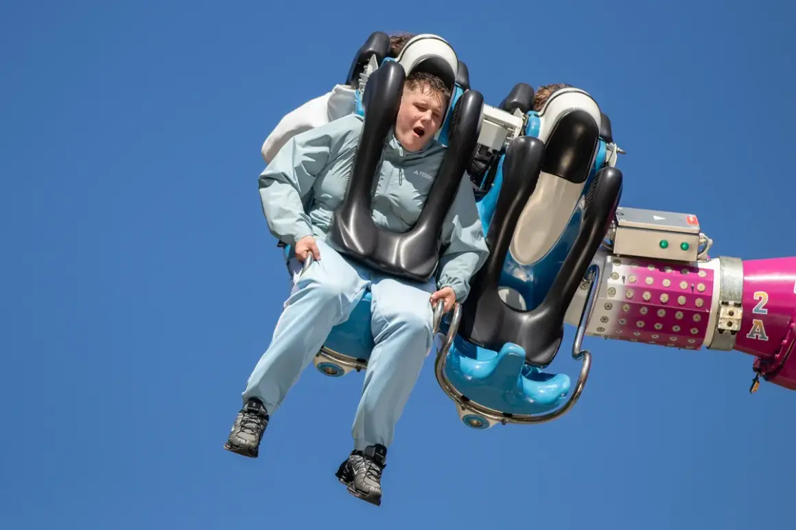 Junge auf einer wilden Fahrt auf der Kirmes Ründeroth, der Wind weht durch sein Haar.