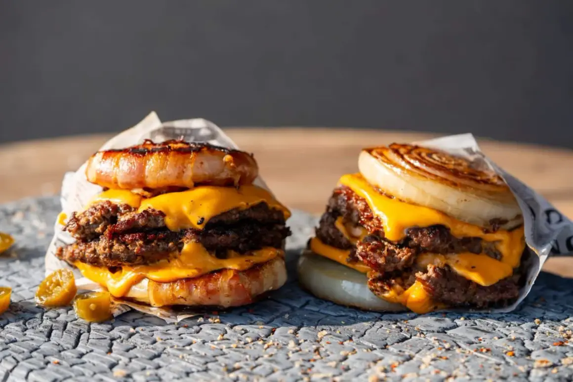 Zwei saftige "Flying Dutchman Burger" mit doppelt Fleisch, geschmolzenem Käse und einer Zwiebel- bzw. Speckkrone.