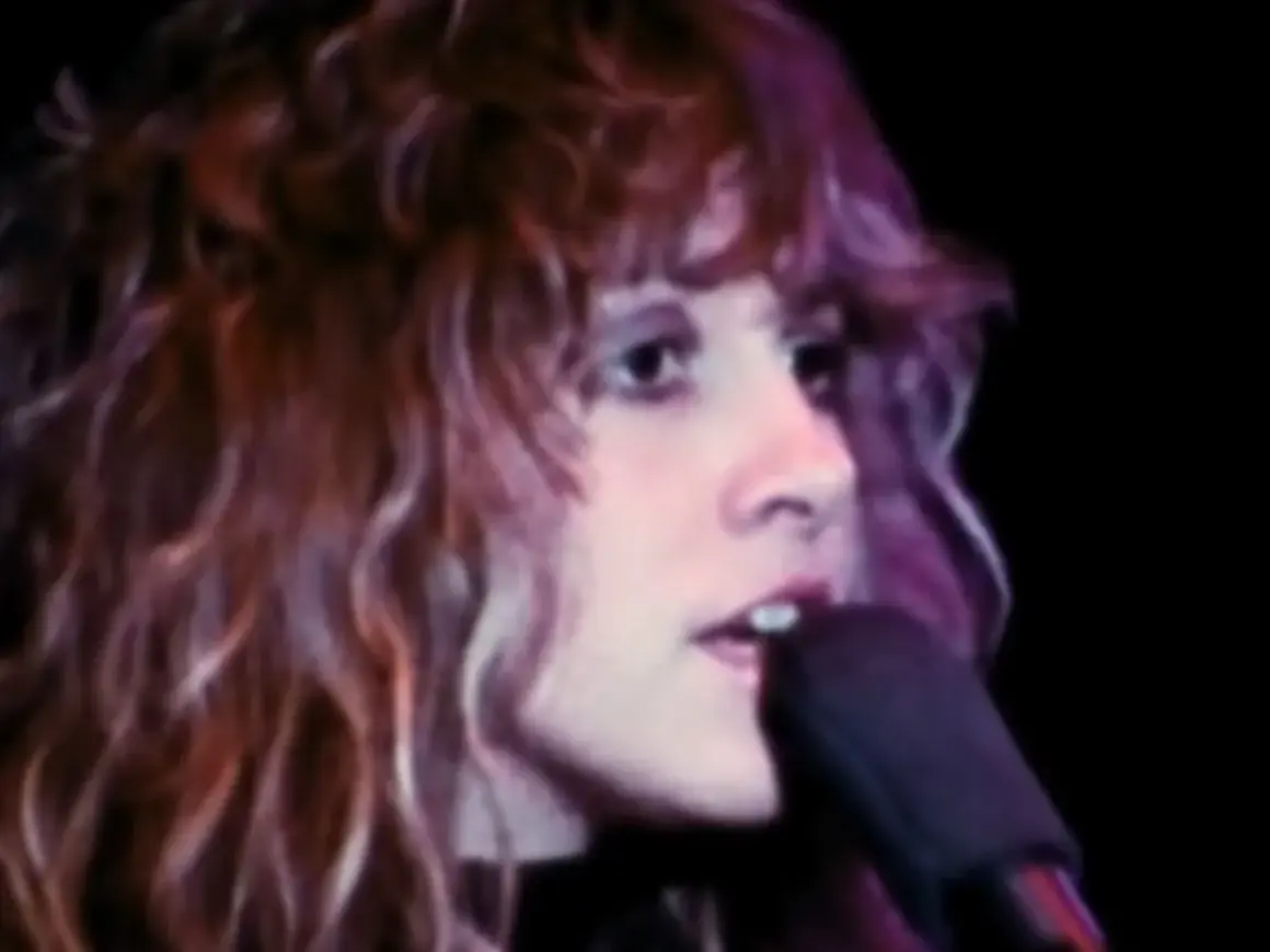 Stevie Nicks śpiewa "Dreams" Fleetwood Mac, jej charakterystyczne falujące włosy i intensywne spojrzenie.