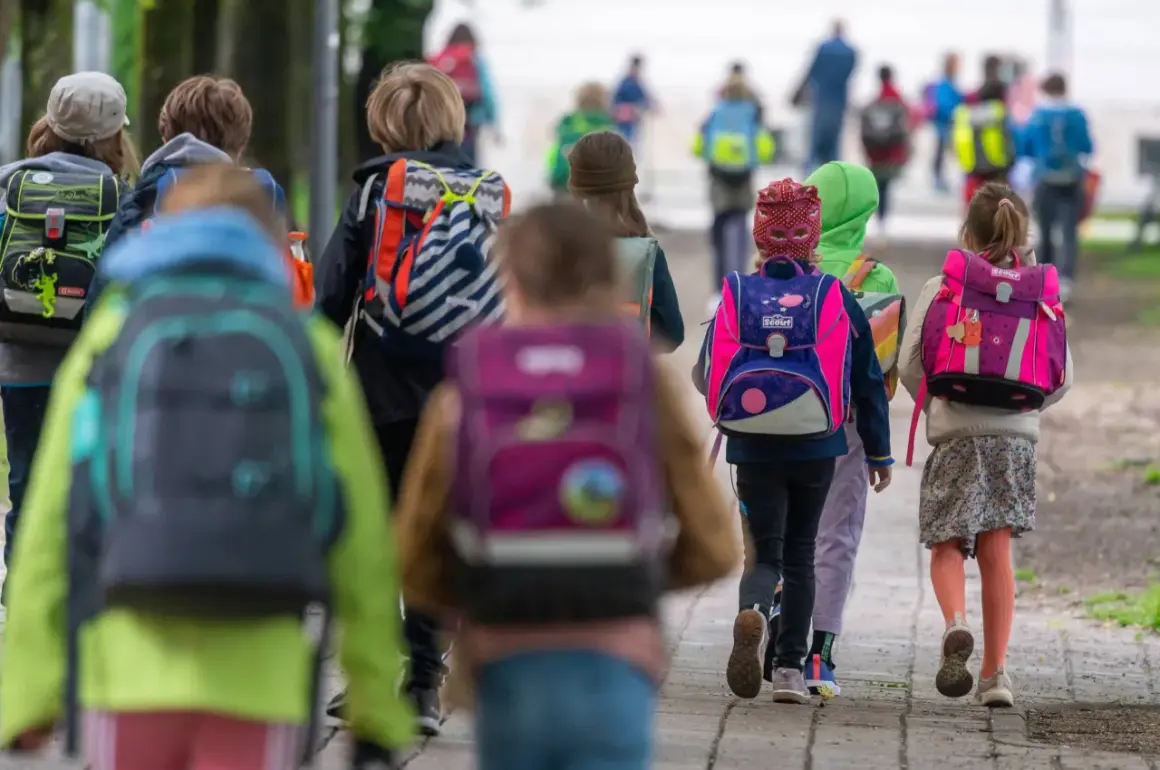 Kinder mit bunten Schulranzen gehen gemeinsam auf dem Weg zur Grundschule. Ein sicherer Schulweg ist wichtig für alle.