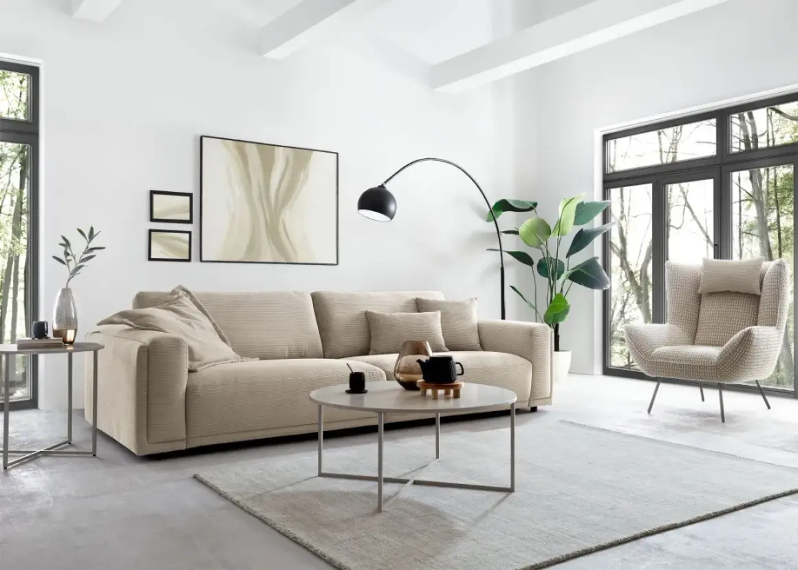 Gemütliches Wohnzimmer mit beigem Sofa, Sessel und Couchtisch. Tolle wohnideen modern für ein stilvolles Zuhause.