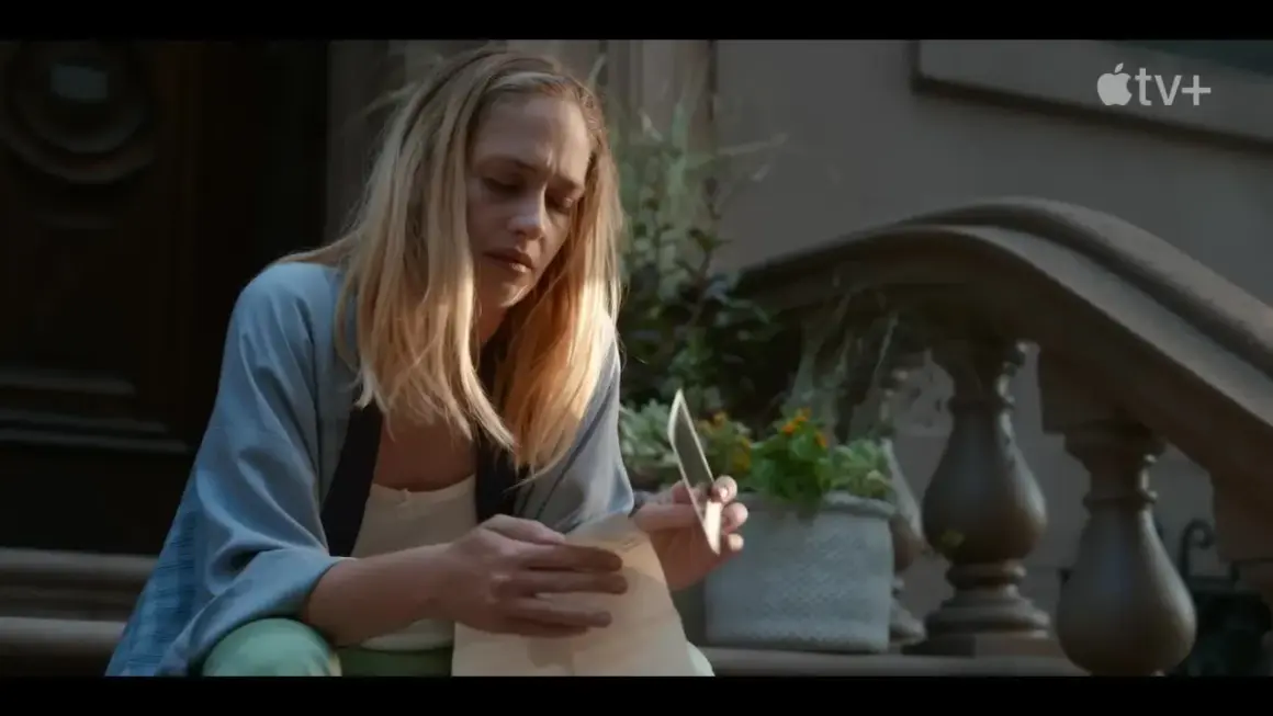 Jemima Kirke sitter på trappan och läser ett brev med en kniv i handen. En scen från filmer och tv-program med Jemima Kirke.