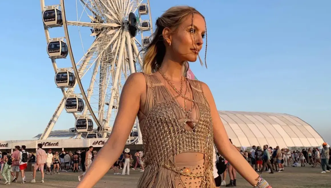 Una ragazza con glitter sul viso e un abito dorato, sullo sfondo la ruota panoramica e la folla: ecco cos'è il Coachella, un festival di musica e moda.