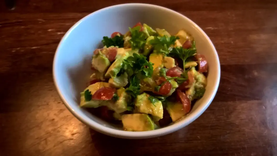 En skål med krämig pico de gallo, toppad med färsk persilja. Perfekt tillbehör!
