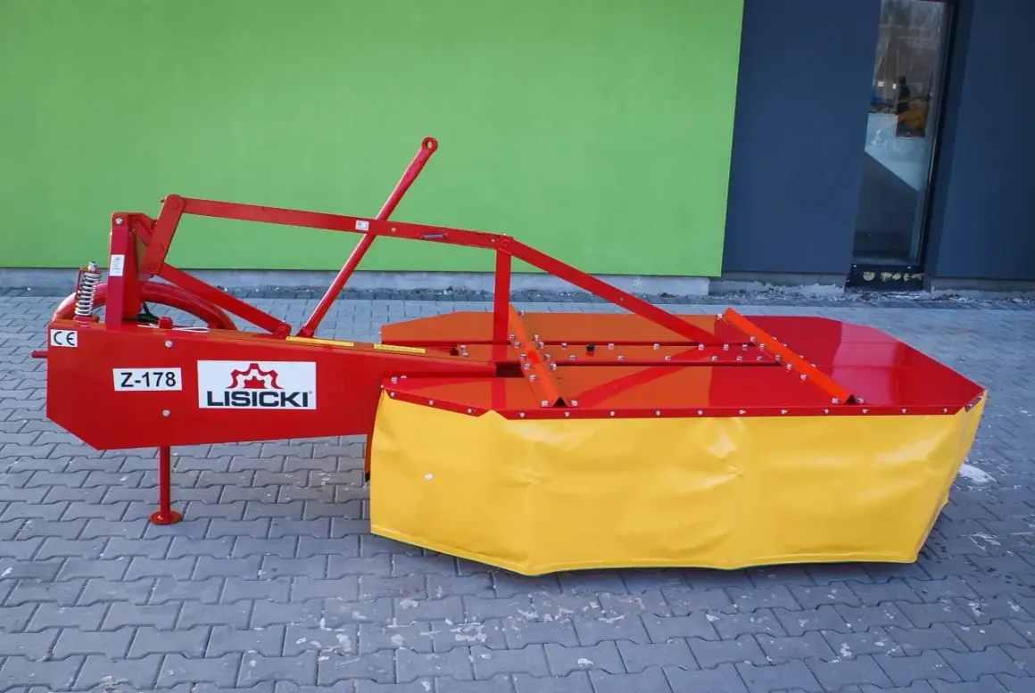 Nowa kosiarka rotacyjna Lisicki Z-178 w kolorze czerwono-żółtym, gotowa do pracy na polu.