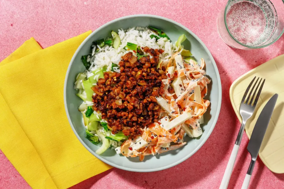 En skål med ris, grönsaker och en kryddig topping. Ett gott kålrabbi recept som ser aptitligt ut.
