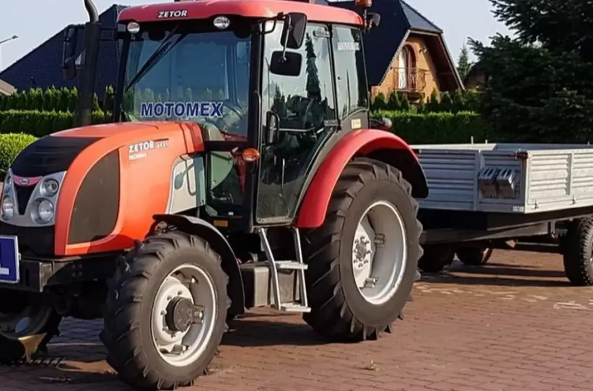 Czerwony traktor Zetor z przyczepą. Zastanawiasz się, ile kosztuje prawo jazdy na traktor?