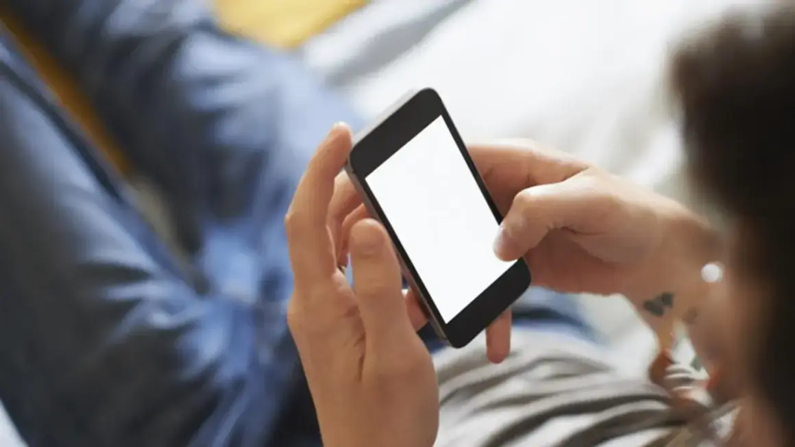 Dłonie trzymają smartfon, ekran świeci pustym blaskiem. Zastanawiasz się, jak schłodzić telefon? Oto kilka wskazówek.