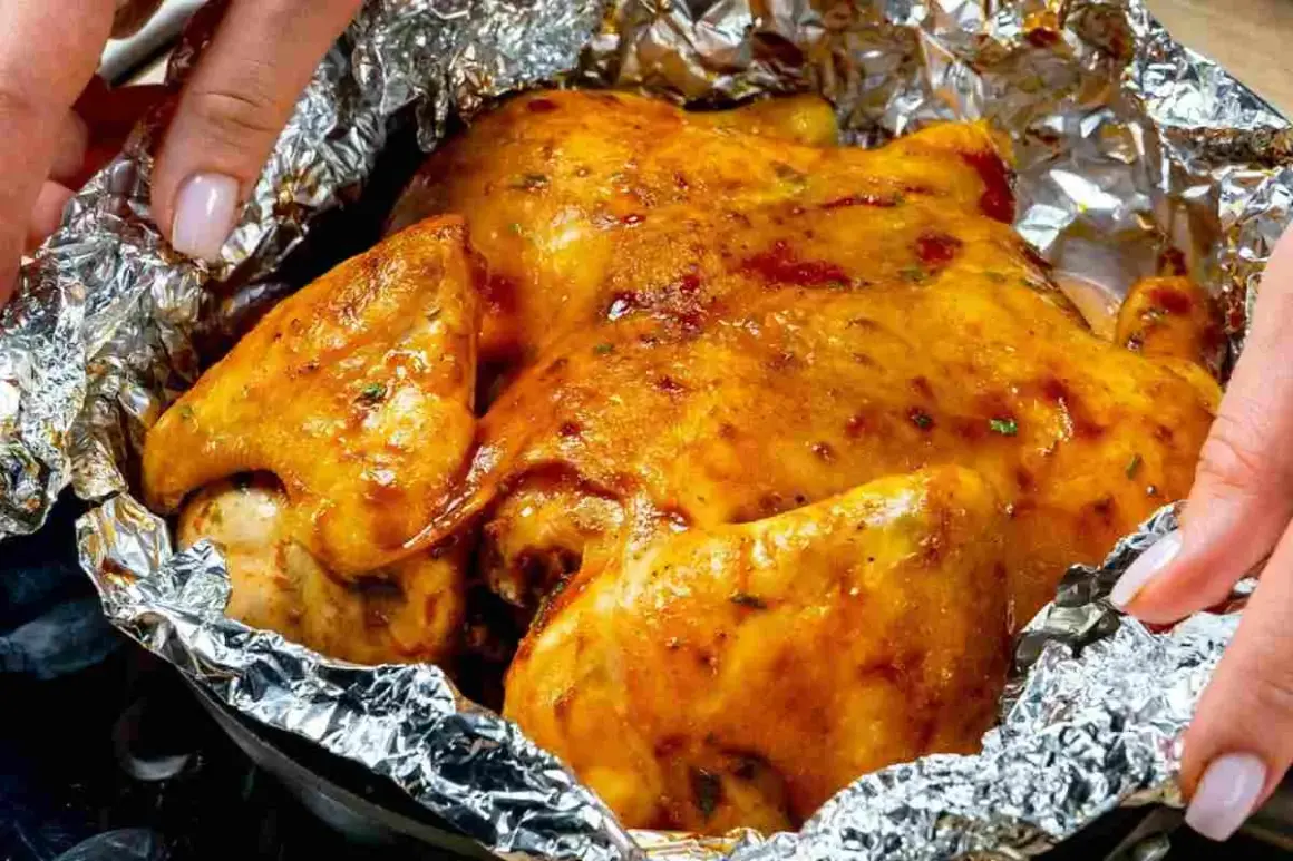 Un succulento petto di pollo dorato, cotto in carta stagnola, pronto per essere gustato.