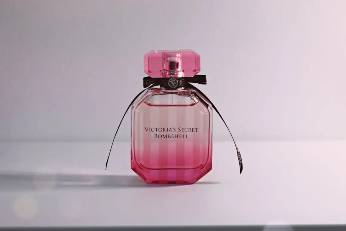 Różowa butelka kultowych perfum damskich Victoria's Secret Bombshell z czarną wstążką.
