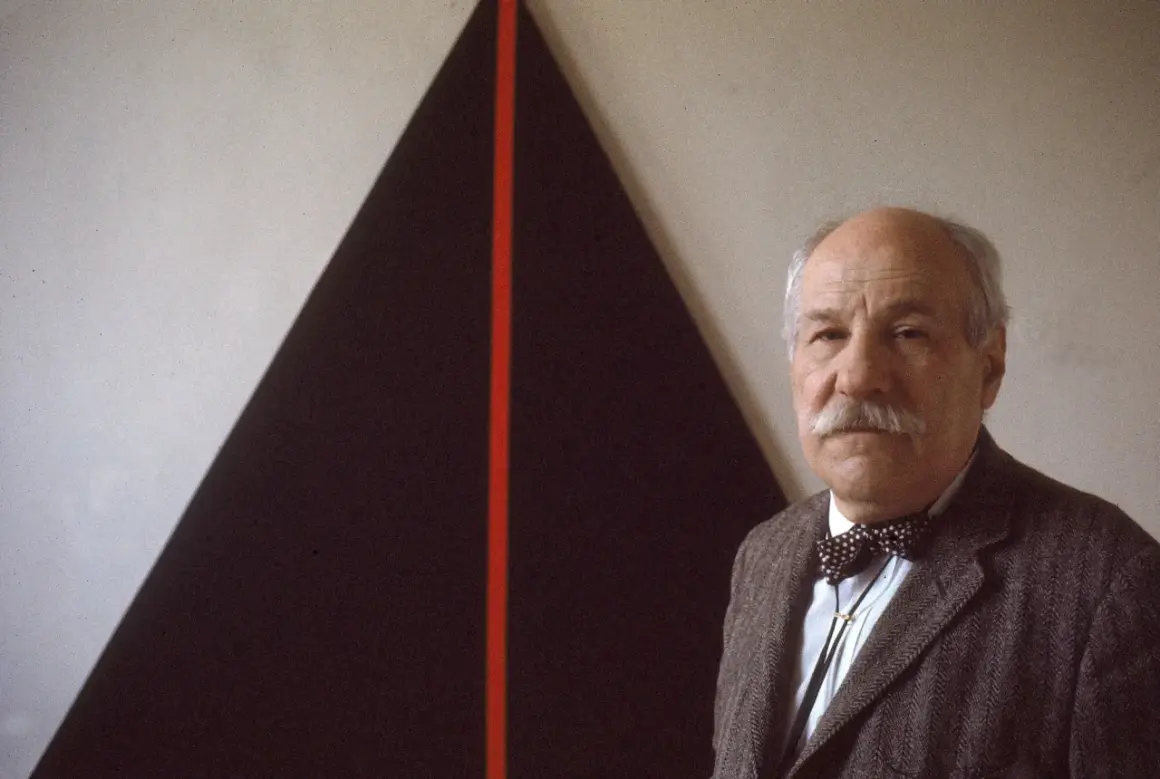 John Plaster poses in front of a striking abstract painting, possibly at the Guggenheim.
