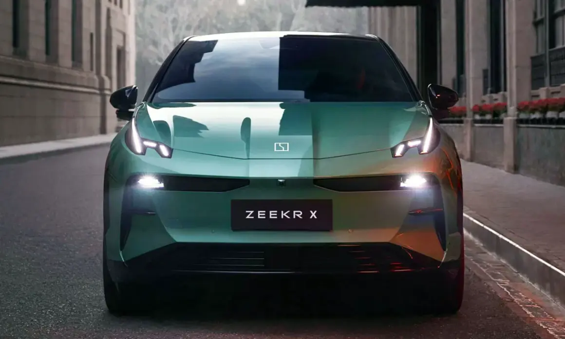 El elegante Zeekr X verde se detiene en una calle urbana, sus luces LED brillan intensamente.