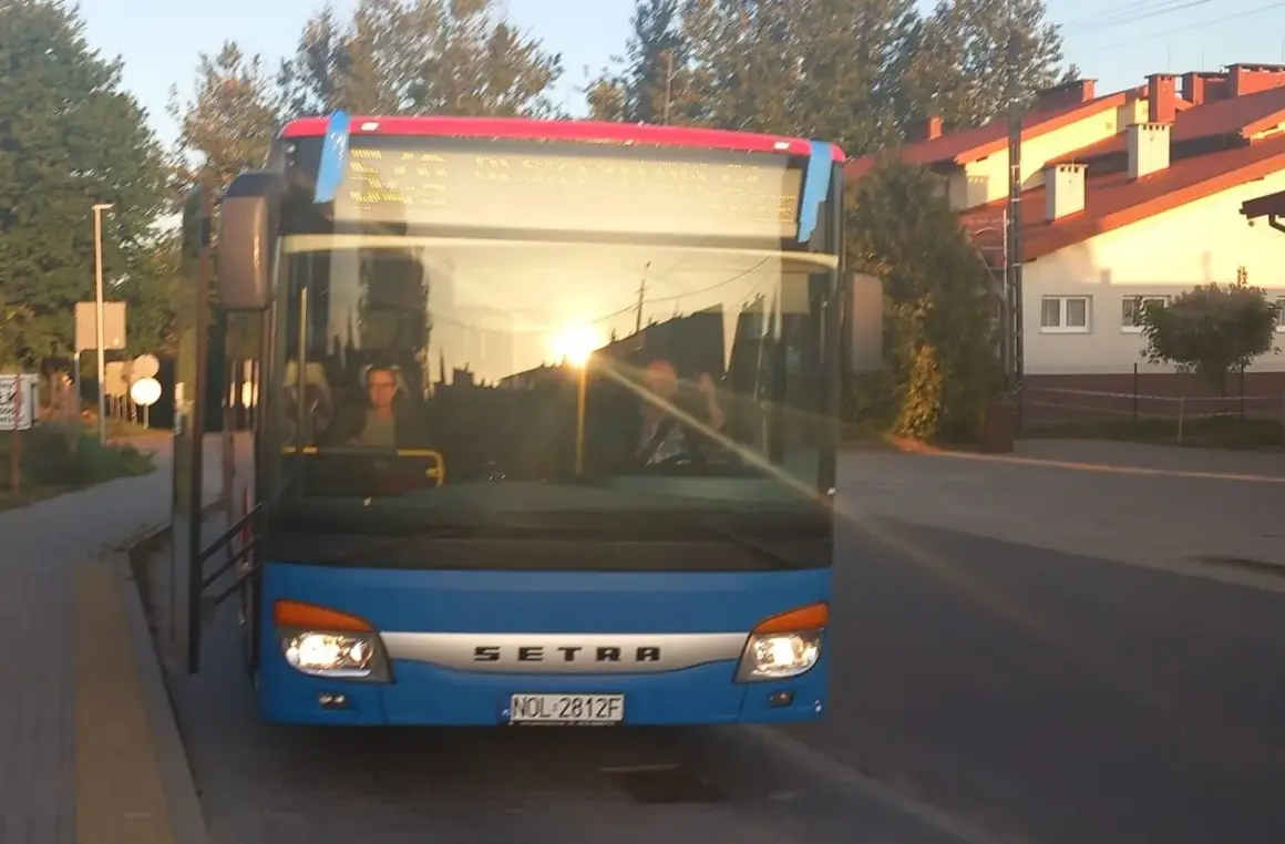 Niebieski autobus Setra z Giżycka do Olsztyna, sprawdzam express bus Giżycko Olsztyn cena. Słońce odbija się w szybie.