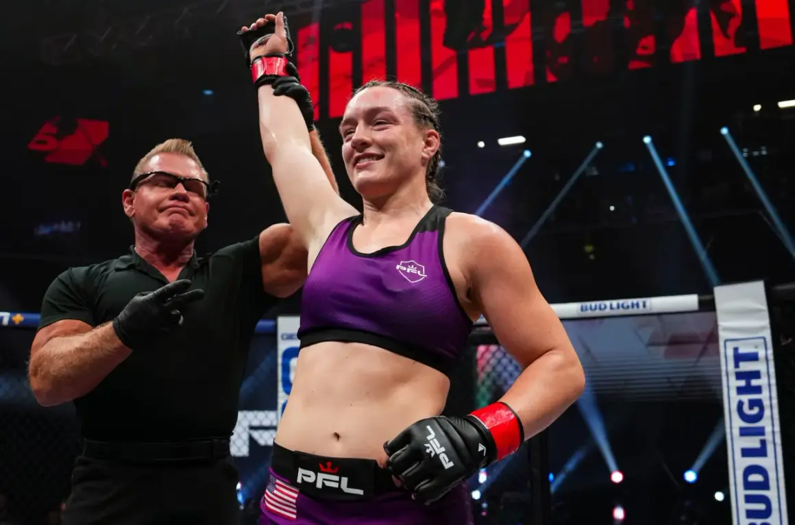 Jessica Rose Clark firar en seger i buren, med domaren som lyfter hennes arm.