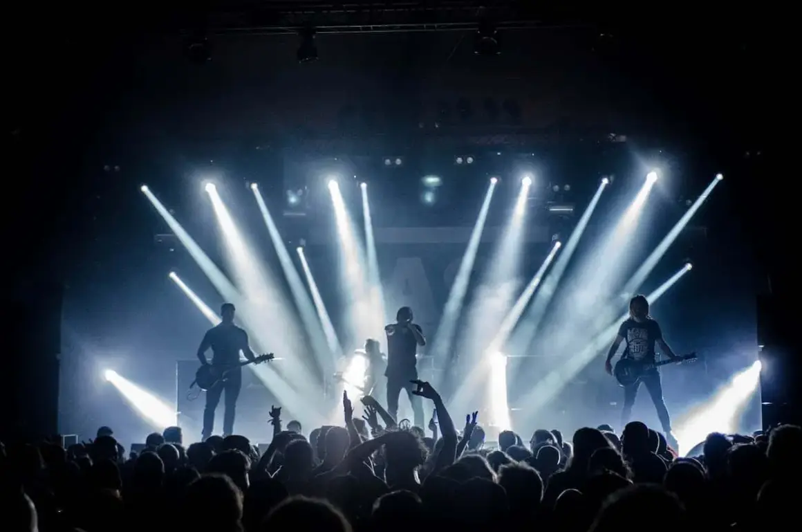 Banda de rock en vivo, luces brillantes y público eufórico. Una escena perfecta para inspirarte en cómo hacer un video musical épico.