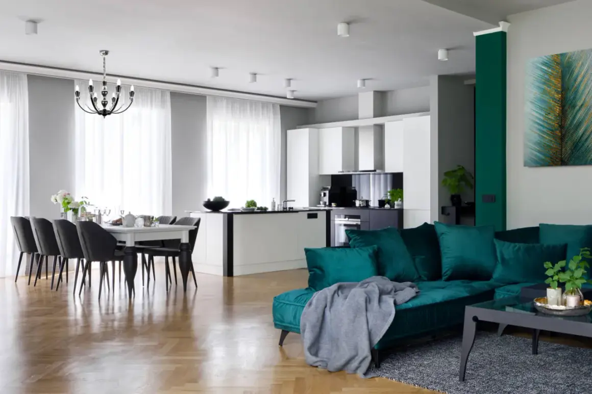Jasne, zwiewne firanki na dwa okna obok siebie tworzą przytulną atmosferę w jadalni.
