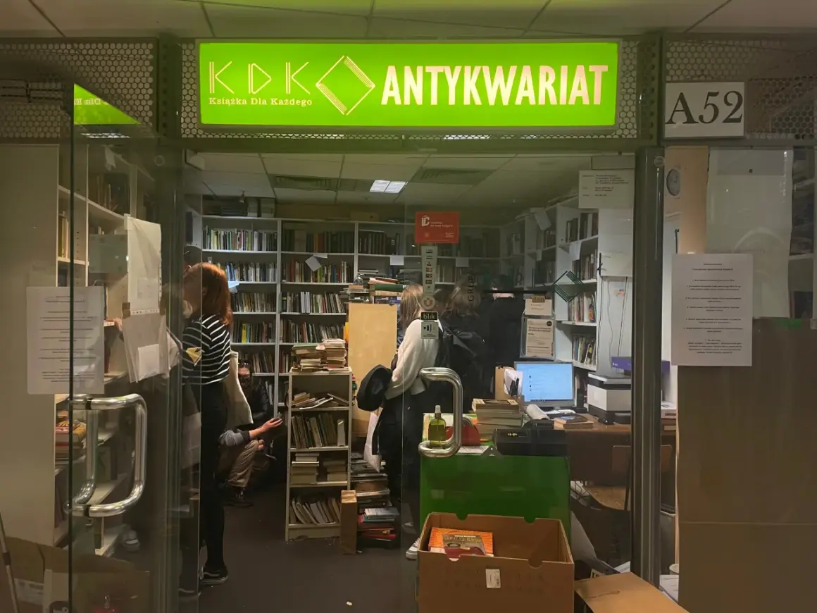 W antykwariacie "Książka Dla Każdego" panuje atmosfera cmentarz zapomnianych książek. Wnętrze pełne regałów z literaturą, gdzie ludzie przeglądają stare tomy.
