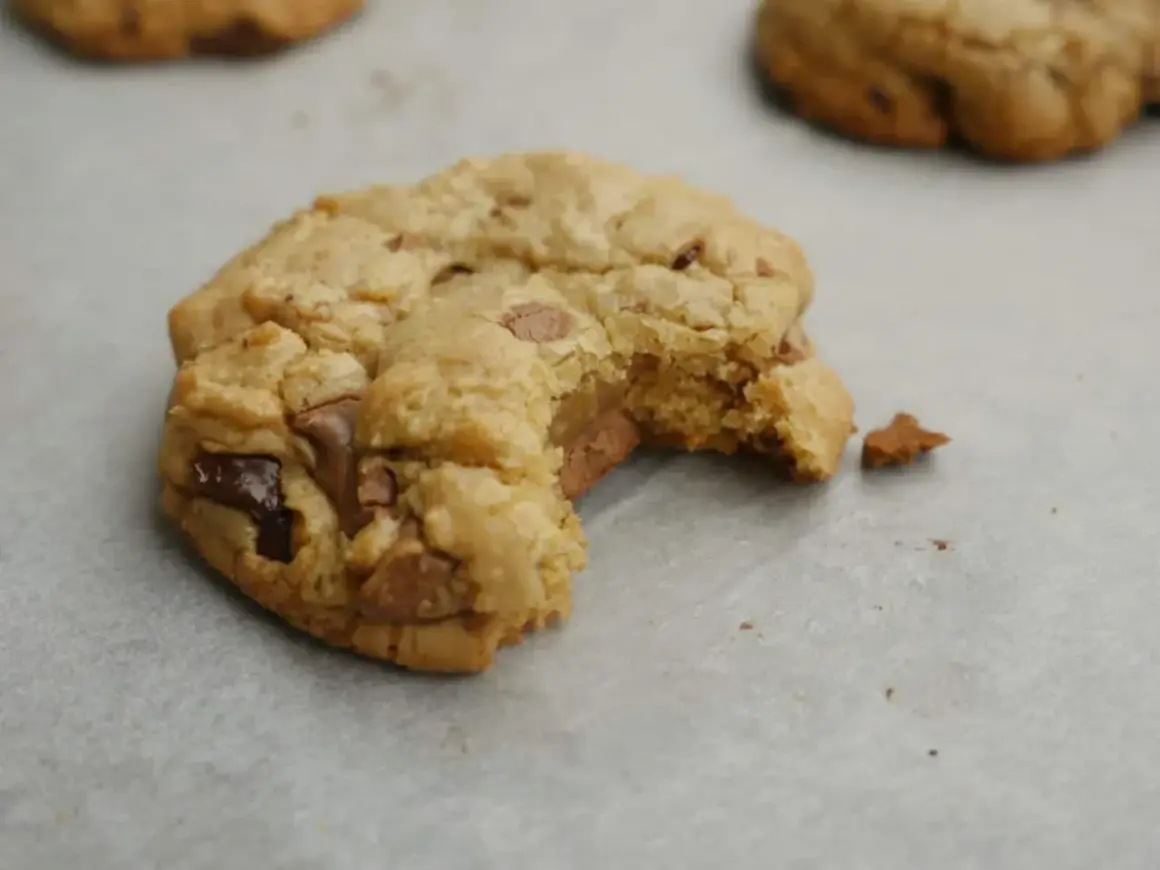 En sega chocolate chip cookies med en bit tagen. Perfekt för ett recept på sega chocolate chip cookies.