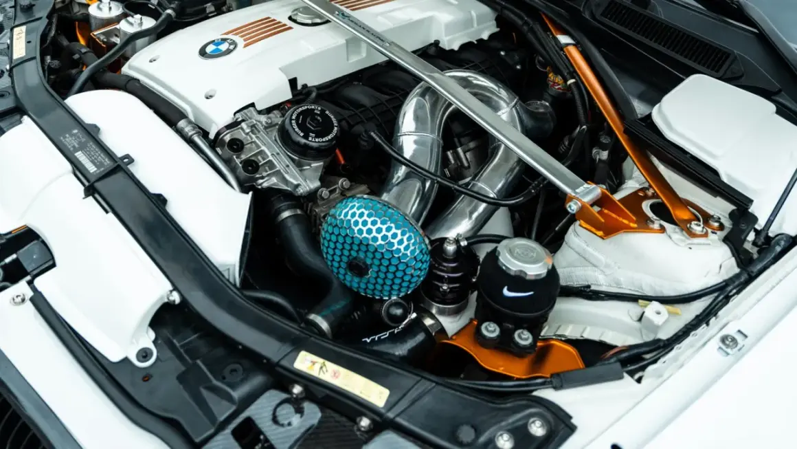 Motor tuning en un BMW: filtro de aire azul, intercooler cromado y refuerzo naranja.