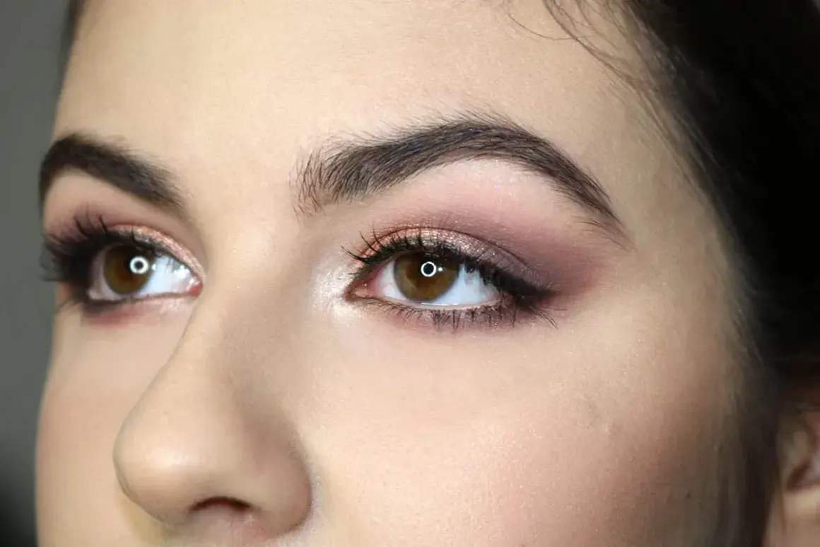 Occhi marroni con ombretto rosa e marrone, ciglia lunghe e eyeliner. Un esempio di come truccare gli occhi per un look sofisticato.