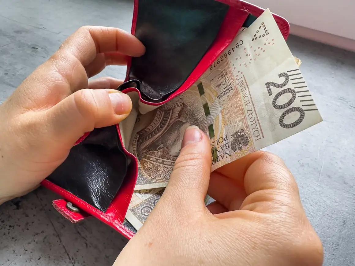 Dwie ręce wkładają banknot 200 zł do czerwonego portfela. Czy kosiniakowe wlicza się do dochodu?