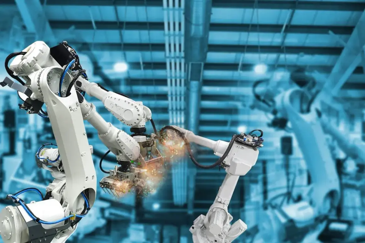 Różne rodzaje robotów przemysłowych pracują w fabryce, spawając elementy z iskrami.