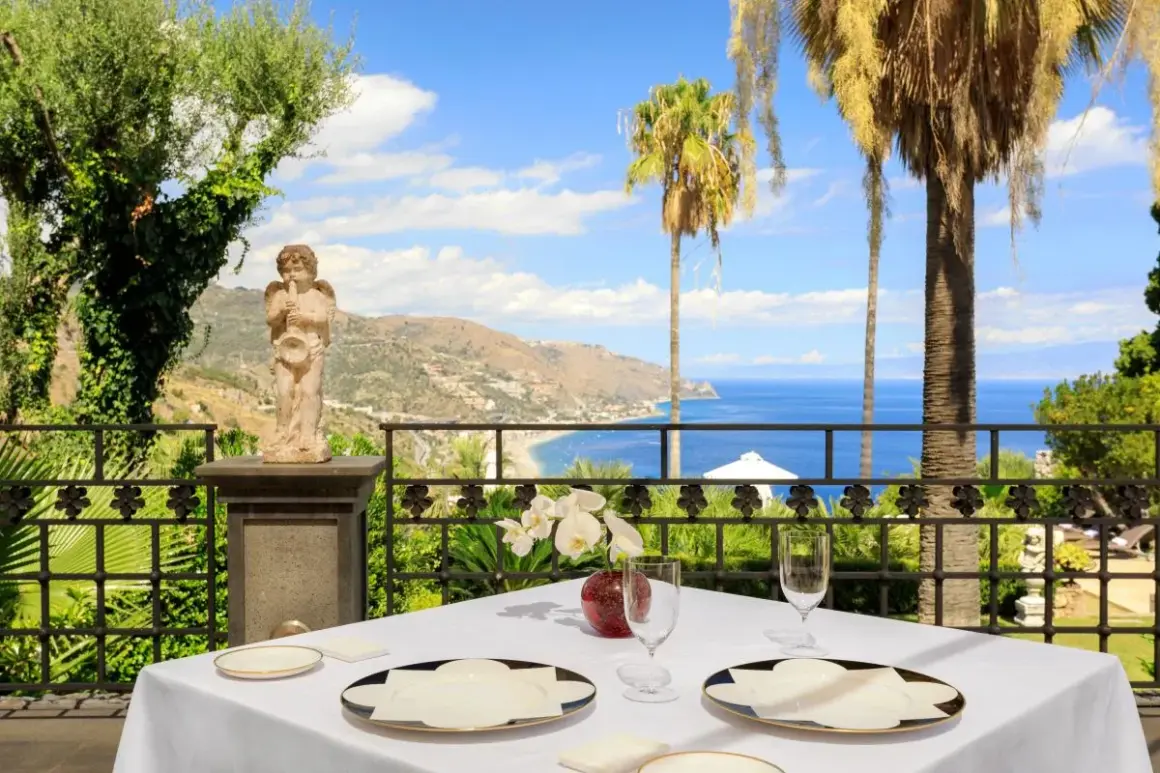Tavola apparecchiata con vista mare a Taormina, un'esperienza tra i migliori ristoranti.