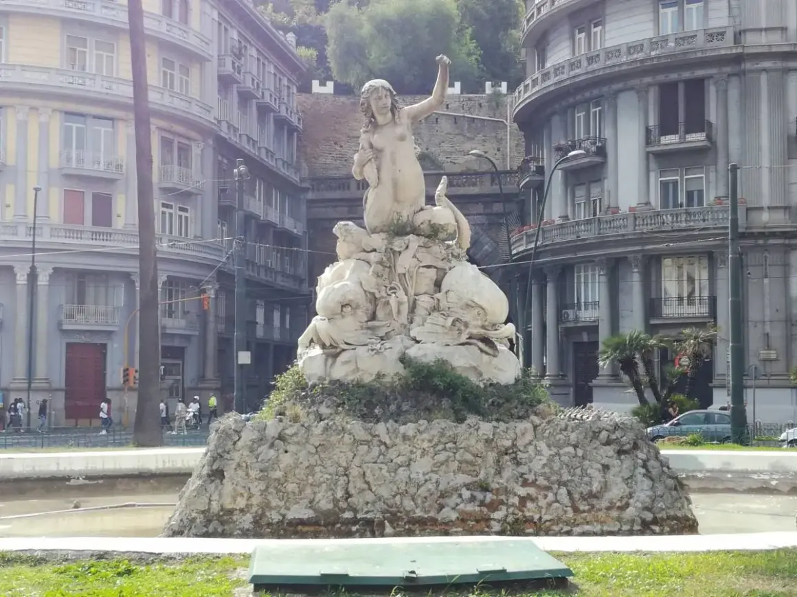 Fontana con statua di Partenope, figura mitologica legata a Ulisse, circondata da creature marine.