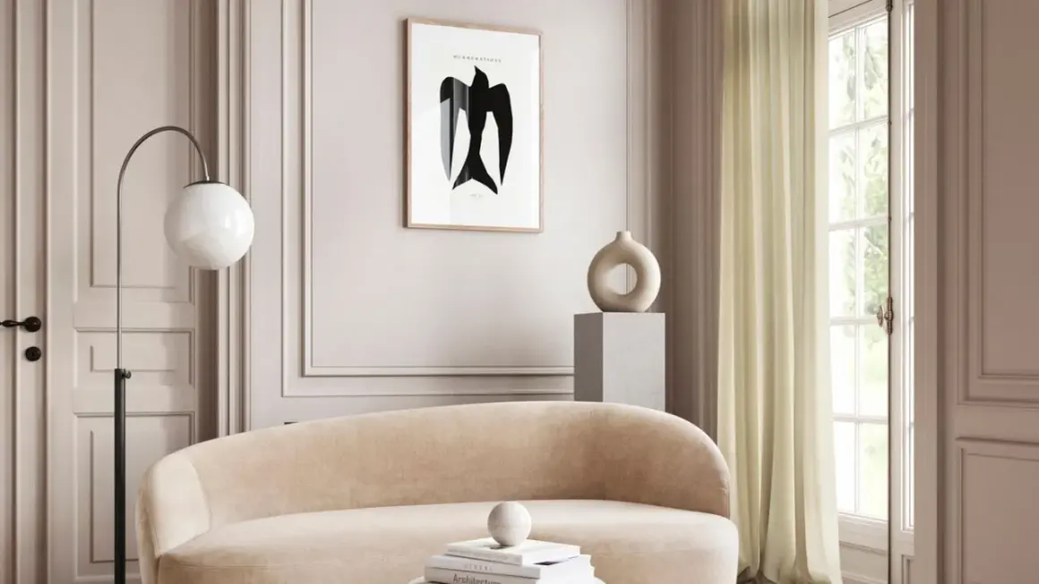 Ein gemütliches Wohnzimmer in greige farbe mit einem geschwungenen Sofa, einem modernen Stehlampen und einem Kunstwerk mit einem Vogel.