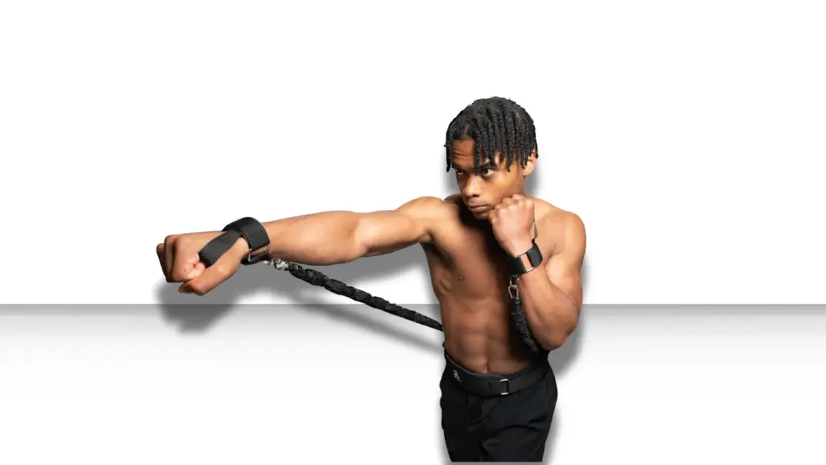 A boxer trains to punch faster using resistance bands attached to his wrists, building explosive power.