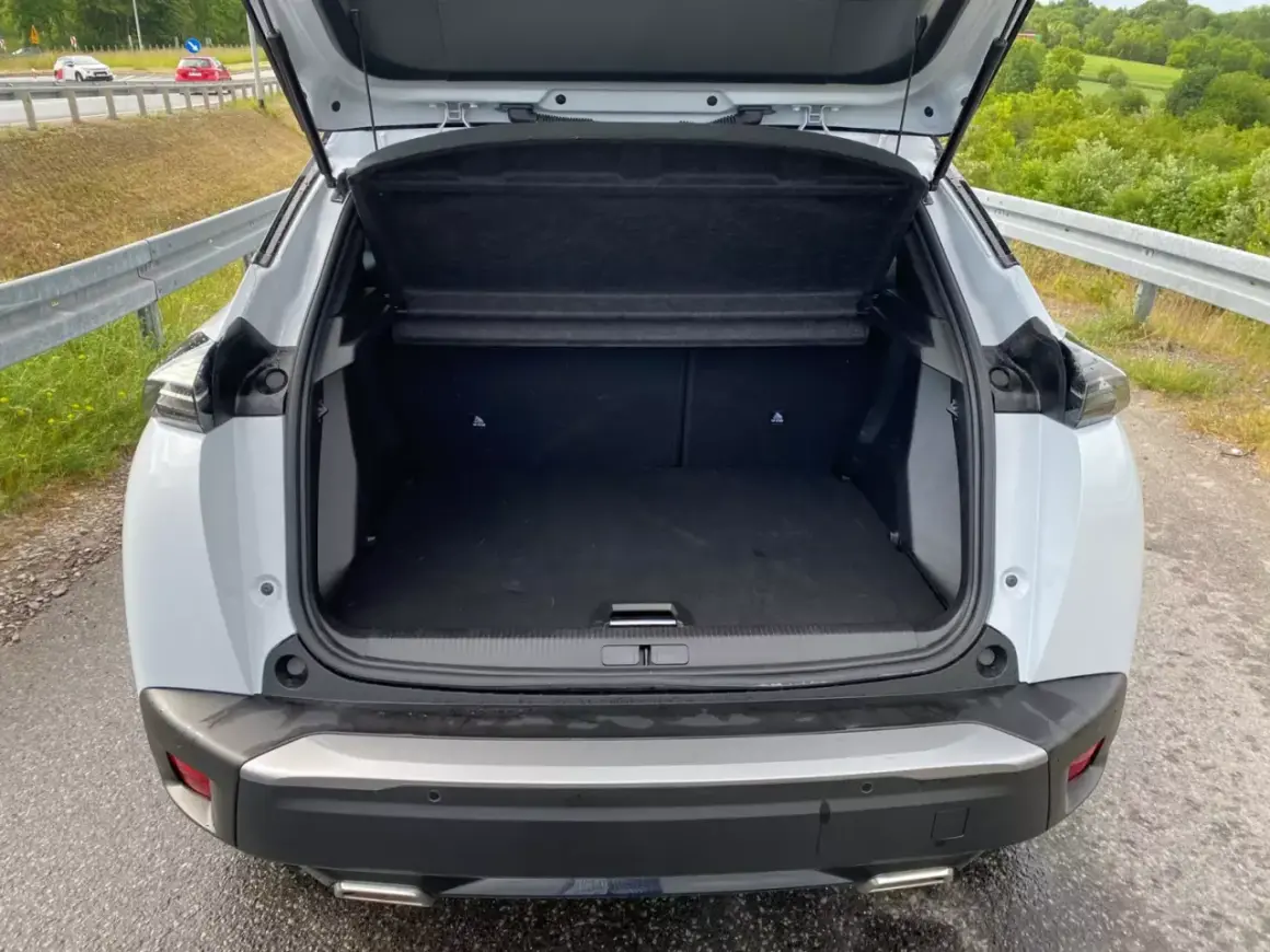 Otwarty bagażnik białego Peugeot 2008. Wymiary tego SUV-a pozwalają na wygodne pakowanie.