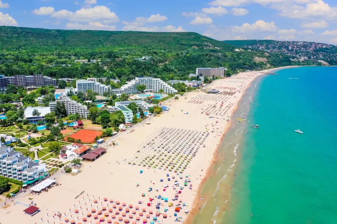 Słoneczna plaża w Złotych Piaskach, Bułgaria. Widok z lotu ptaka na hotele, leżaki i turkusowe morze. Ceny w Bułgarii Złote Piaski zachęcają do wypoczynku.