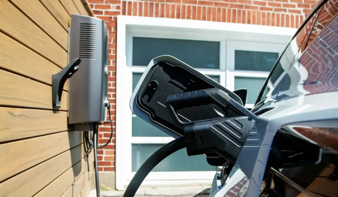 Ładowanie samochodu elektrycznego. Stacja ładująca podłączona do pojazdu, magazyn energii z samochodu elektrycznego gotowy do pracy.