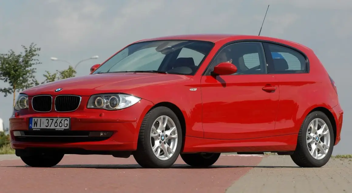 Czerwone BMW Seria 1, zgrabne auto miejskie, gotowe na każdą podróż.