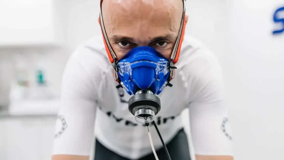 Mężczyzna w masce do testów wysiłkowych, badający swoje VO2max.