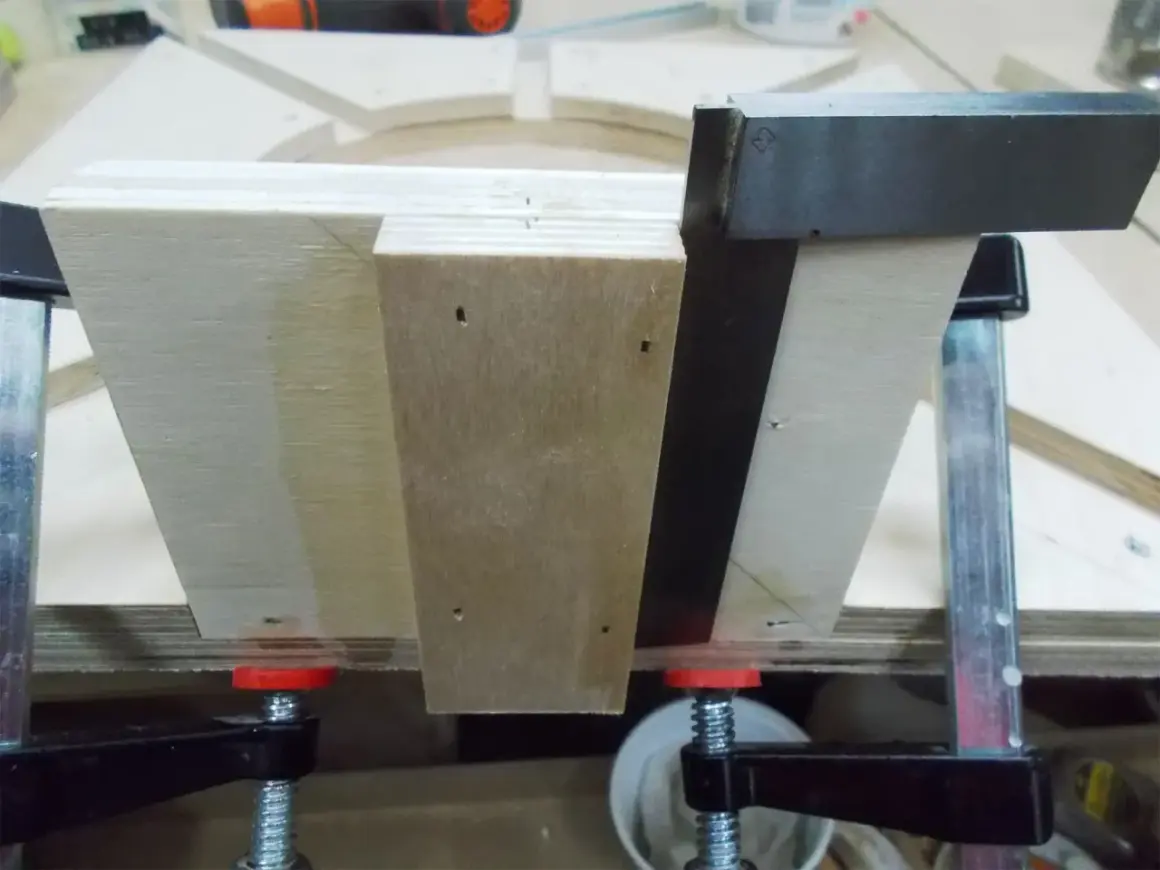 Assemblage d'un plan lunette de tournage en bois, maintenu par des serre-joints.