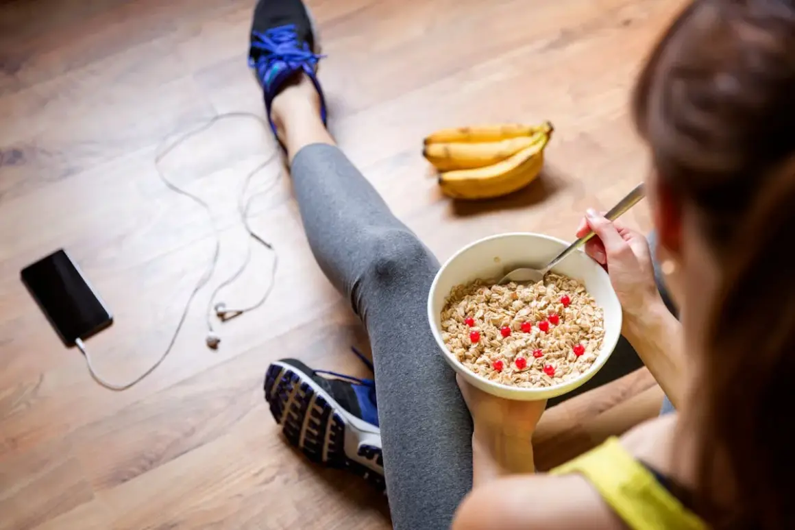 Après l'effort, un bol de flocons d'avoine avec des fruits rouges, une collation parfaite pour une nourriture healthy. Des bananes et un téléphone à proximité.