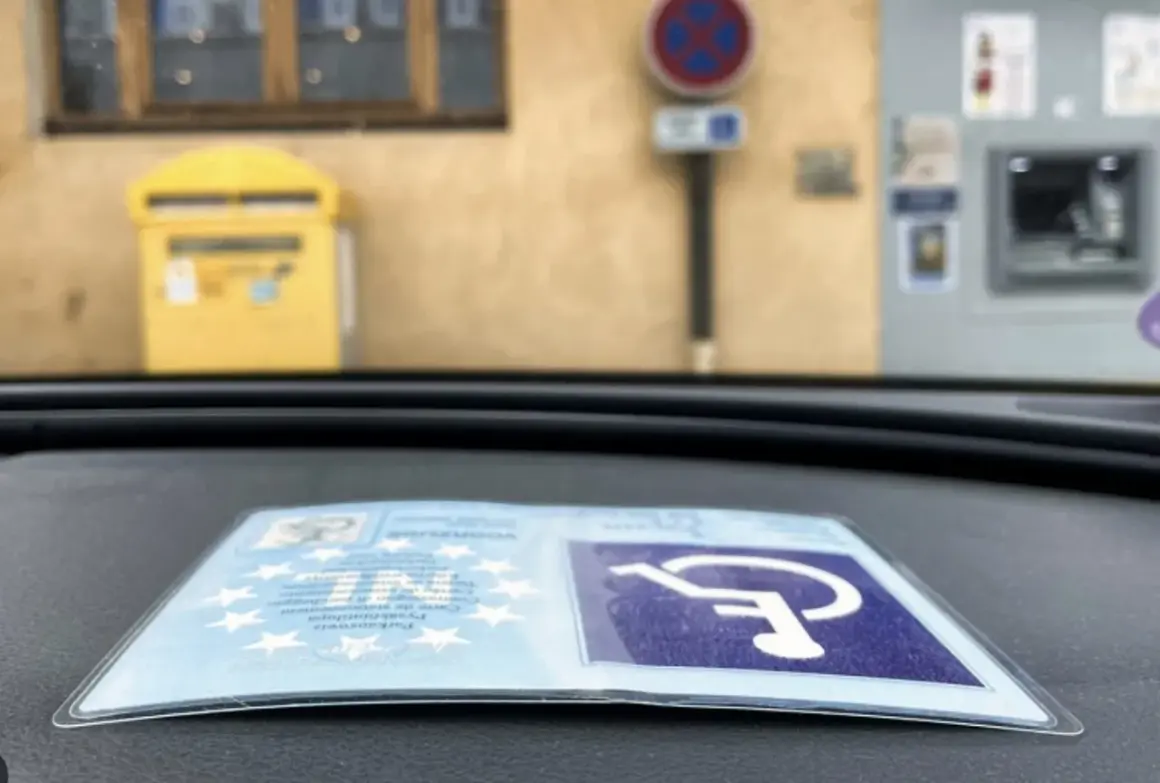 Karta parkingowa dla niepełnosprawnych uprawnienia, symbol wózka inwalidzkiego na niebieskim tle.