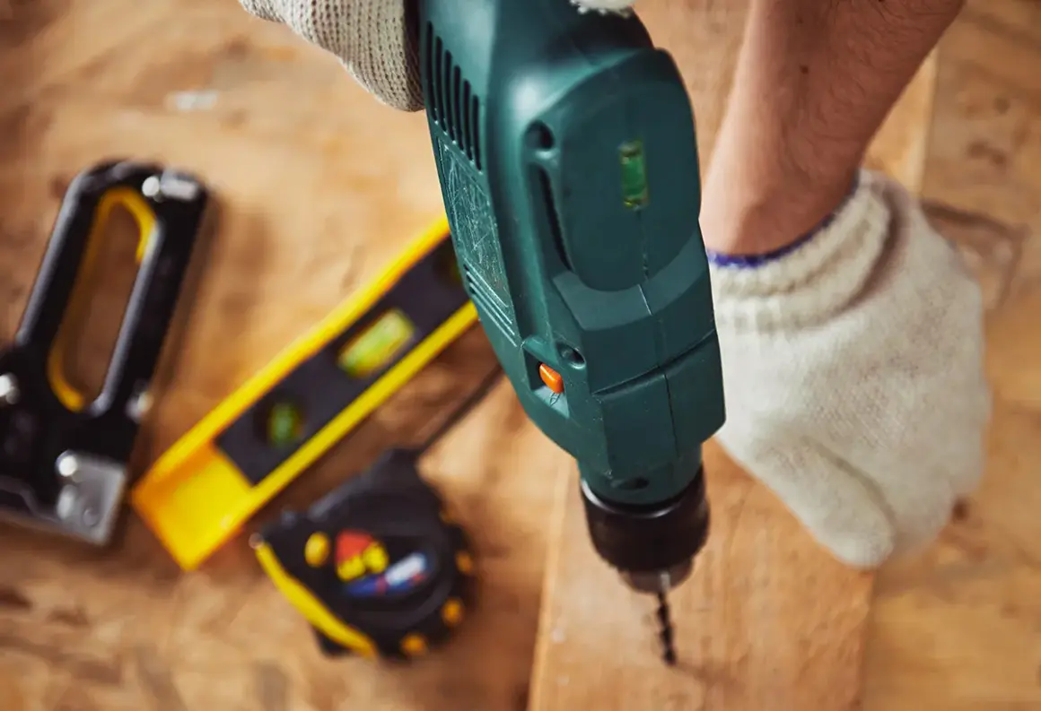 Une perceuse sert à faire des trous dans le bois, comme le montre cette image avec d'autres outils de bricolage.