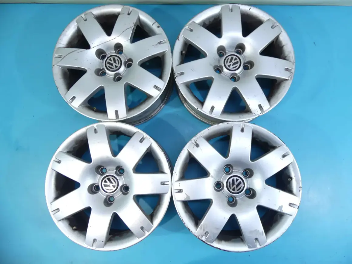 Cztery felgi aluminiowe VW Passat B5, widoczny rozstaw śrub 5x112. Stan dobry, widoczne ślady użytkowania.