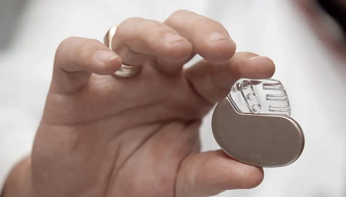 Dłoń trzymająca niewielki pacemaker. Dzięki niemu można wrócić do aktywności, nawet do biegania.