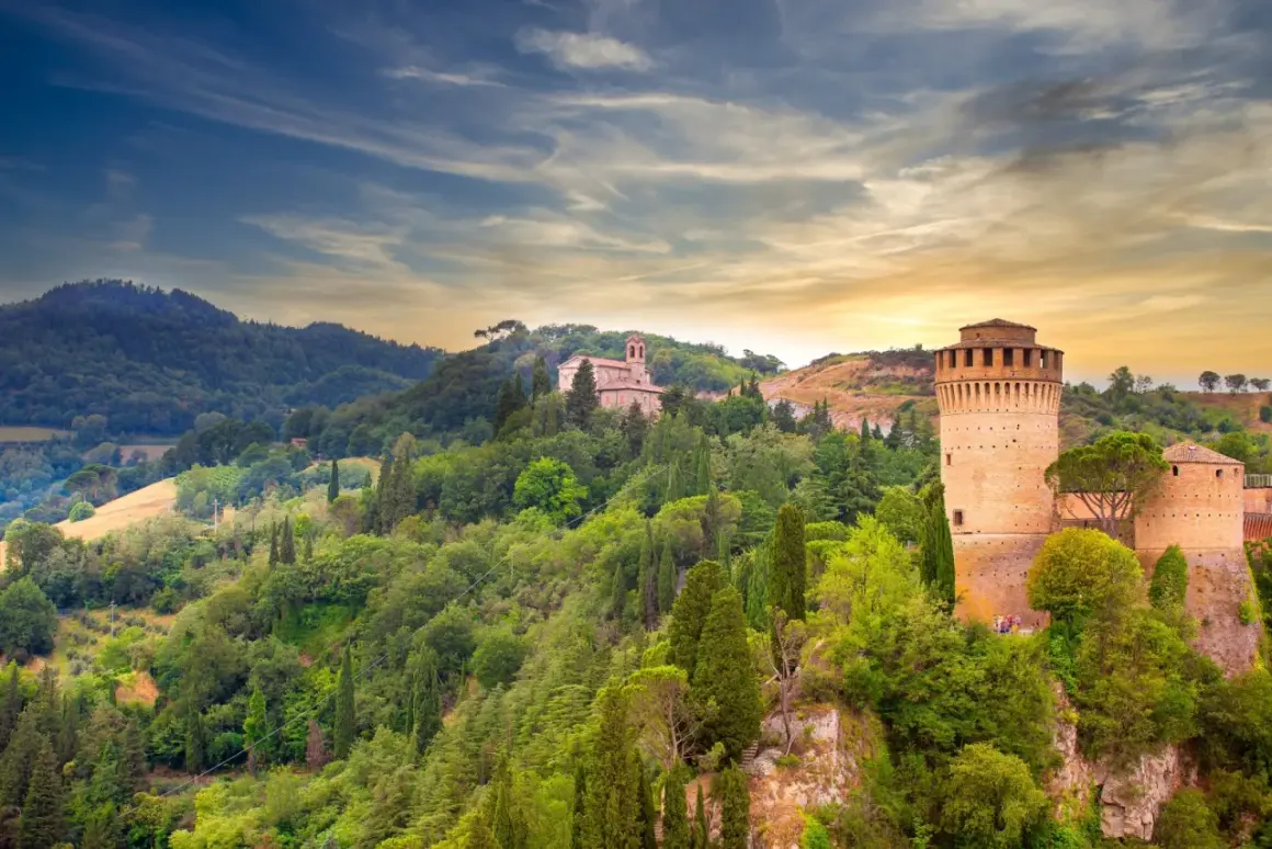 Brisighella, un borgo medievale in Emilia-Romagna, con la sua Rocca Manfrediana e la chiesa sulla collina, immerso nel verde.