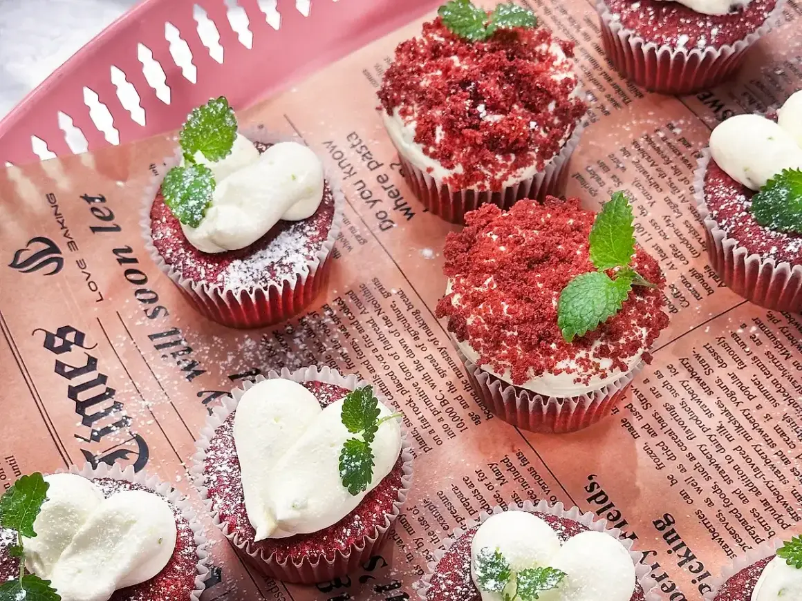 Red velvet muffins med fluffig frosting och myntablad. En härlig syn av röda sammetsmuffins!