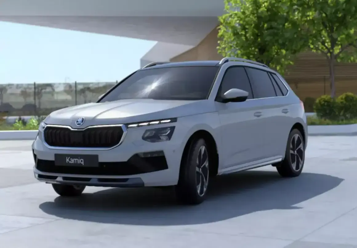 Jasnoszary SUV Skoda Kamiq z fabrycznym LPG prezentuje się nowocześnie na tle architektury i zieleni.