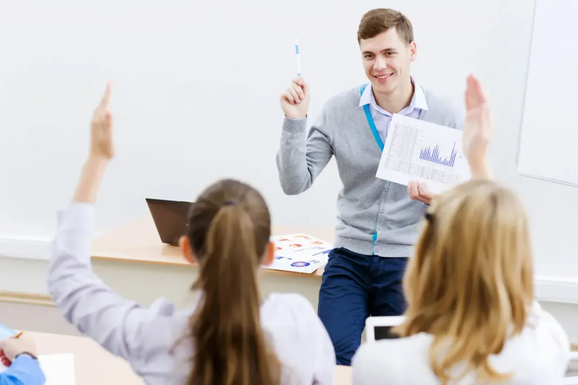 Lehrer erklärt den Unterschied zwischen dualem und berufsbegleitendem Studium. Schüler melden sich.