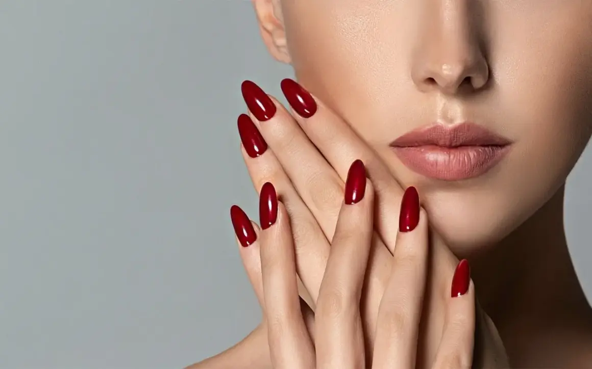 Mani eleganti con unghie a mandorla color rosso ciliegia, perfette per una durata semipermanente impeccabile.