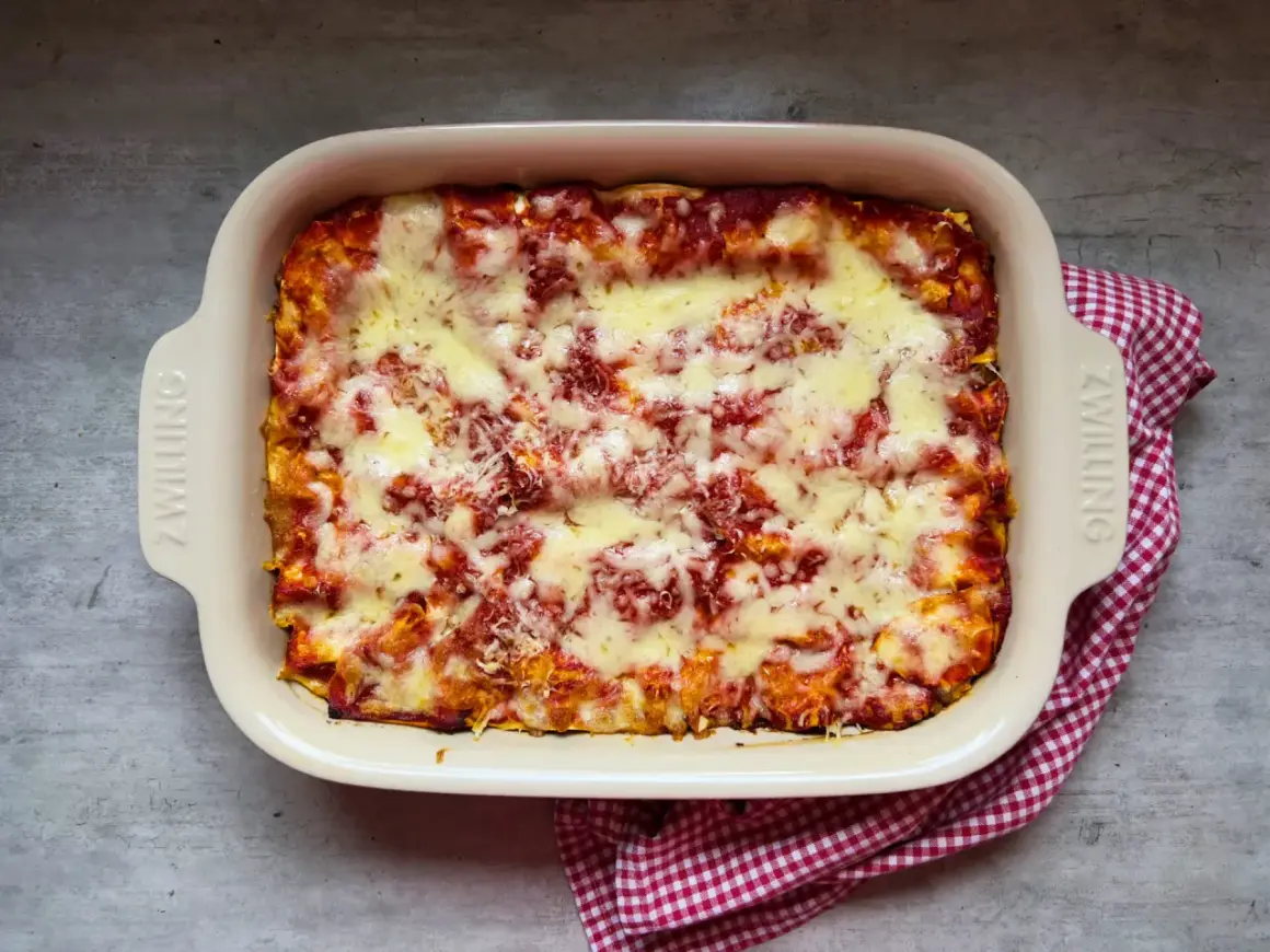 Frisch gebackene Lasagne im Auflaufform, bereit für das nächste lasagne rezept. Überbacken mit geschmolzenem Käse und Tomatensauce.