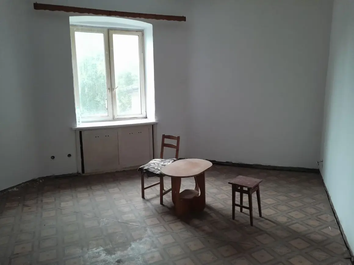 Puste mieszkania za odstępne w Łodzi. Stół, krzesło i stołek czekają na lokatorów.