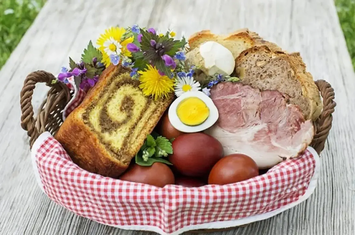 Co się daje do koszyczka wielkanocnego? Widać tu babkę, jajka, chleb, wędlinę i kwiaty.