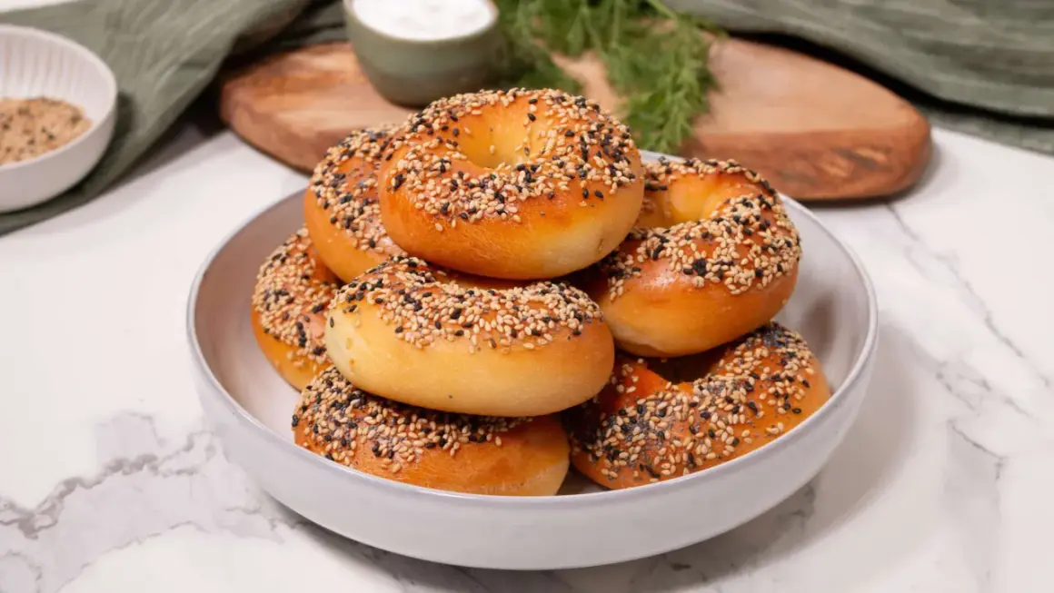 Ein Haufen frisch gebackener Bagels, bestreut mit Sesam und Mohn, perfekt für ein proteinreiches Bagel-Rezept.